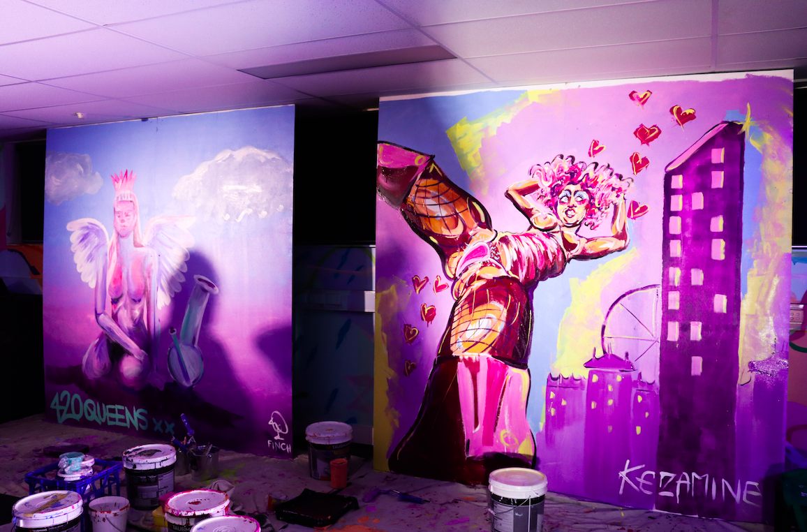 Two finished Scribble Slam panels in pinks and purples after the battle, paint tins on the floor